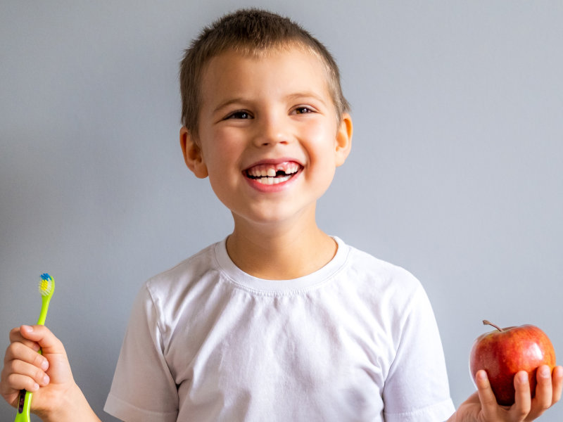 Junge mit Zahnbürste beim Zahnarzt für Kinder